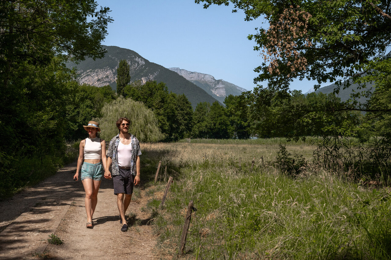 Couple en promenade dans la nature avec montagnes au camping CLICOCHIC Aloua � Sevrier (74).