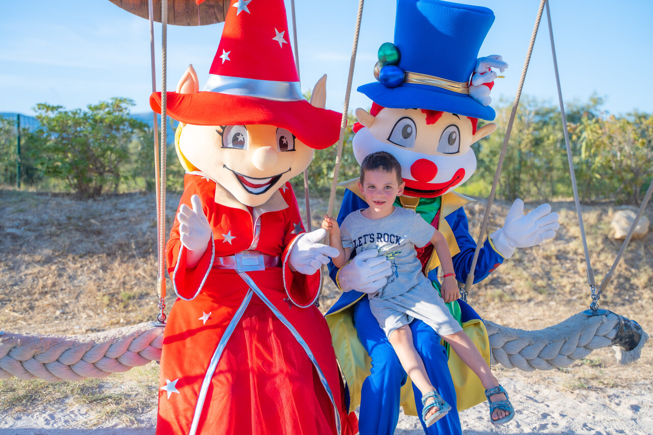 Enfant souriant avec mascottes d'animation au camping CAPFUN Arbois du Castellet � LE CASTELLET (83).