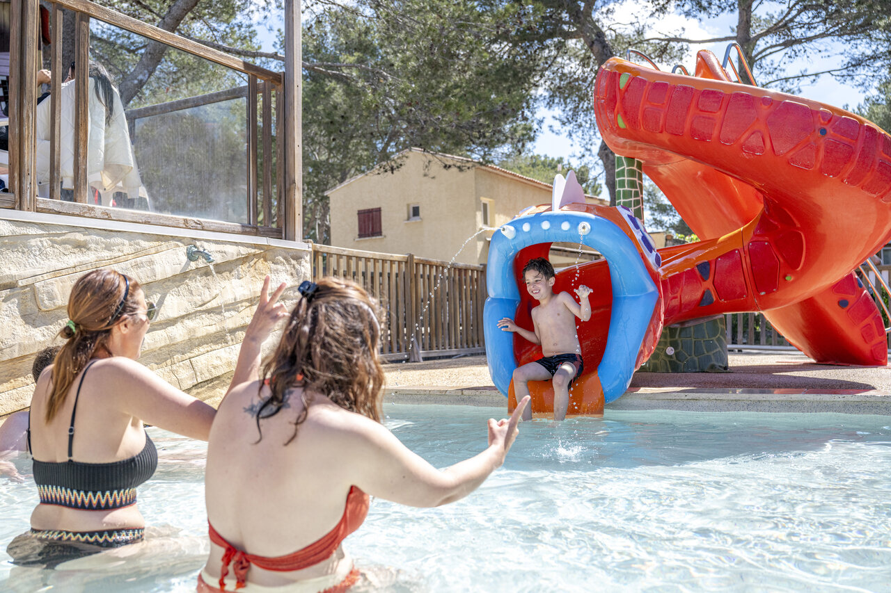 Enfant sur toboggan aquatique et piscine au camping CAPFUN Arbois du Castellet (83).