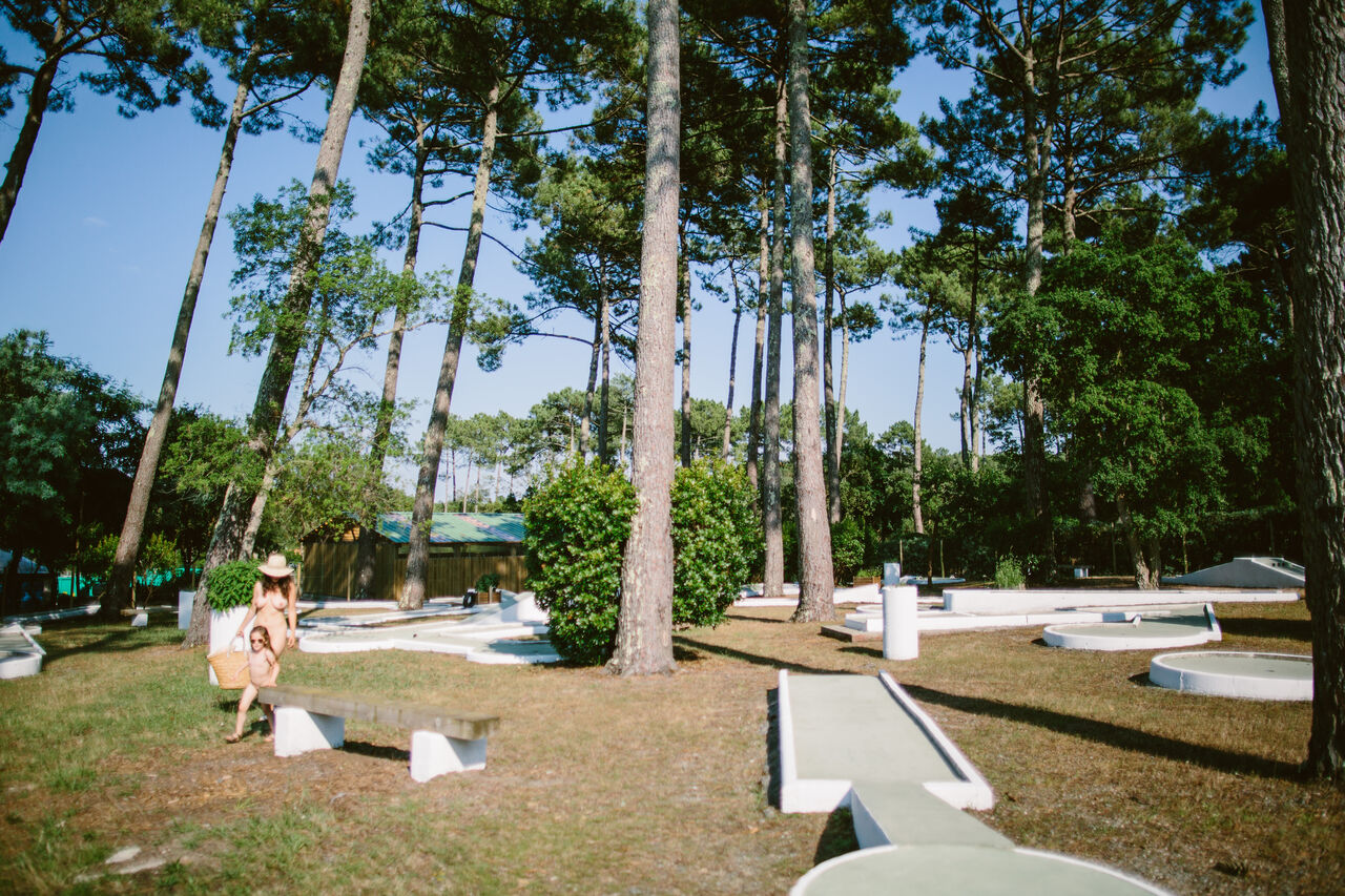 Mini-golf ombrag� sous les pins avec famille au camping LIBRANOO Naturiste Arnaoutchot � Veille-Saint-Girons, Landes, France.