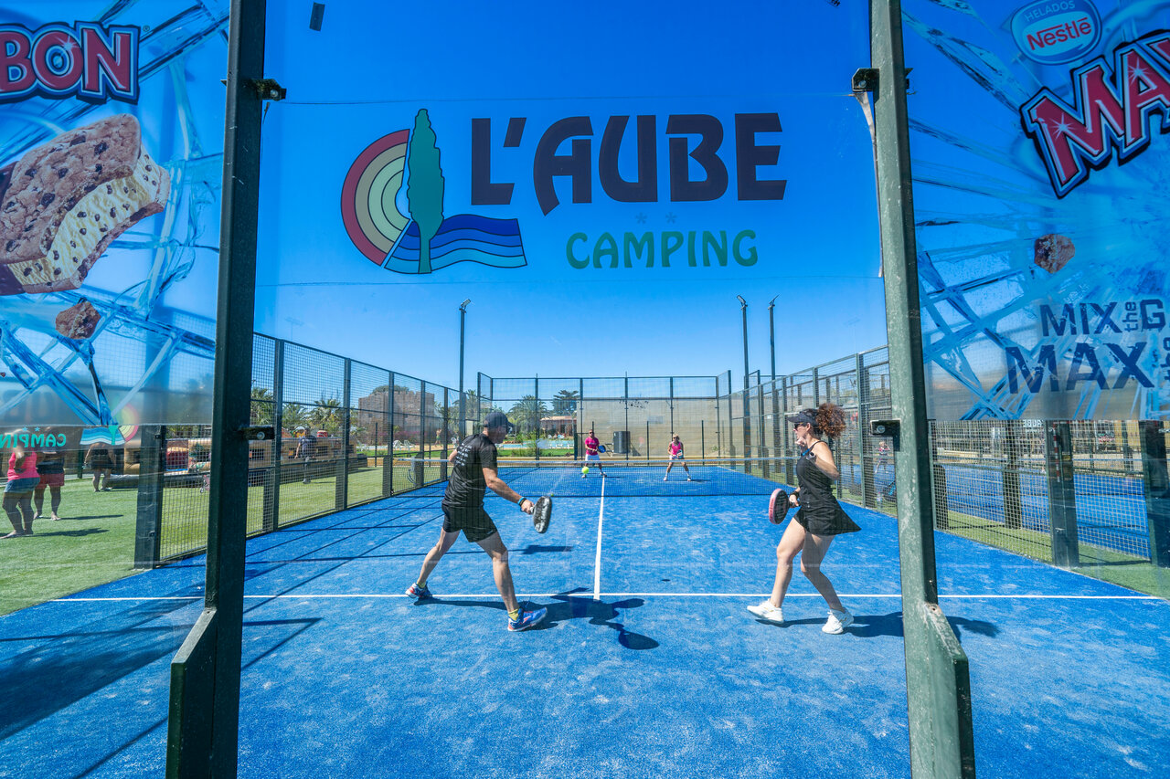 Joueurs sur terrain de padel bleu au camping CAPFUN Aube, Deltebre.