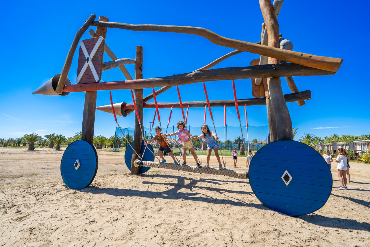 Enfants sur grande structure de jeux en bois au camping CAPFUN Aube, Deltebre.