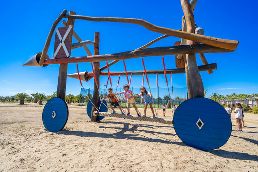 Aire de jeux en bois unique avec enfants sur pont de corde au camping CAPFUN Aube à Deltebre, Tarragone.