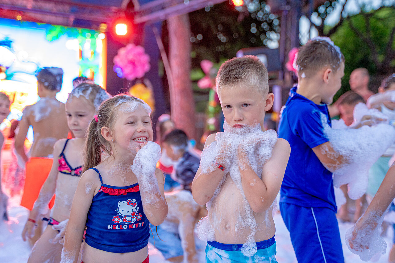 Enfants joyeux jouant dans la mousse lors d'une soir�e animation au camping CAPFUN Aubr�des � Puget sur Argens (83).
