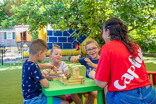 Enfants jouant � un jeu de construction avec animateur au camping CAPFUN Aubr�des � Puget sur Argens (83).