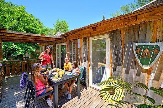 Famille d�jeunant sur terrasse Mobil-home au camping CAPFUN Aubr�des (83).