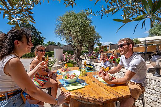Famille déjeunant sur la terrasse du restaurant au camping CAPFUN Barbacane à NARBONNE (11).