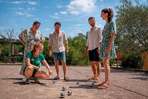 Amis jouant à la pétanque sur le terrain du camping CLICOCHIC Bastets.