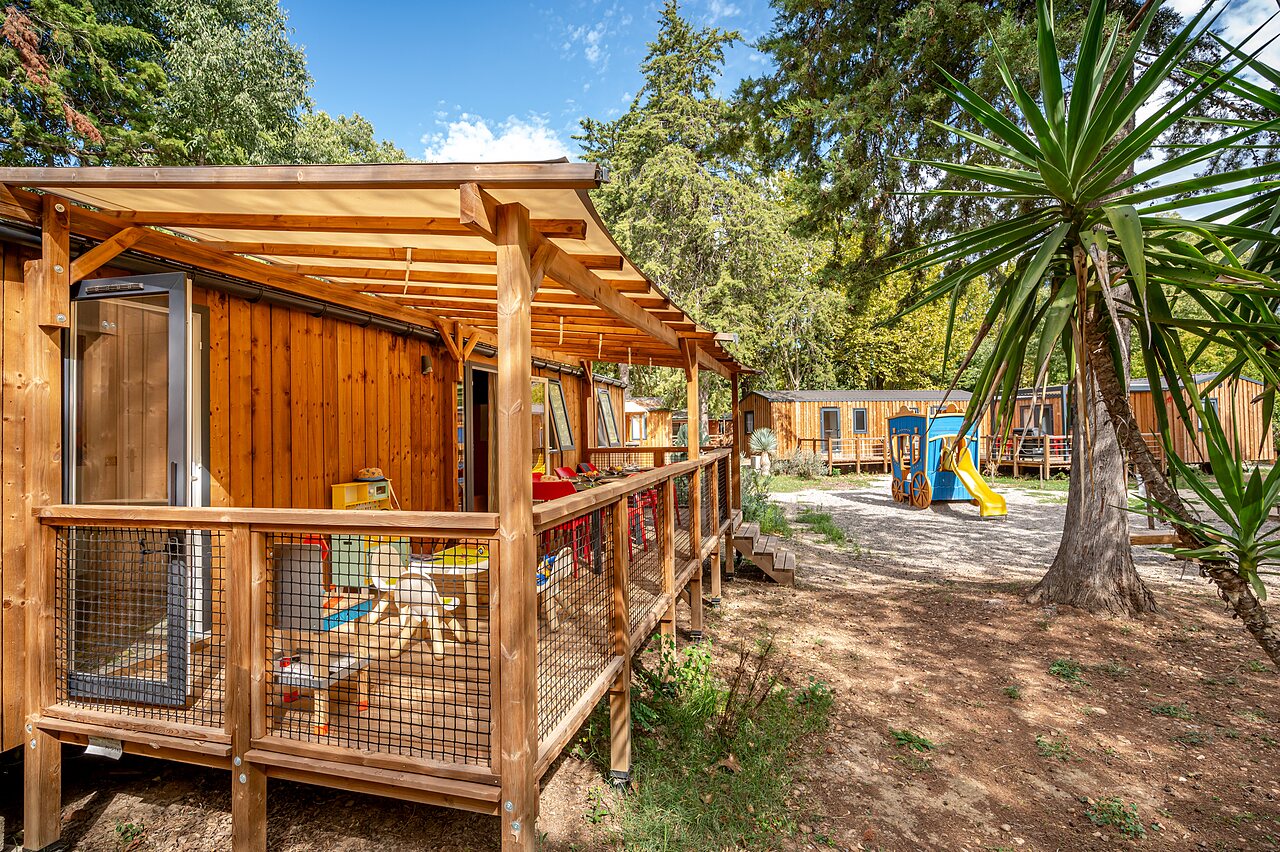 Mobile home en bois avec terrasse couverte et aire de jeux au camping CAPFUN Bastide � N�mes (30).