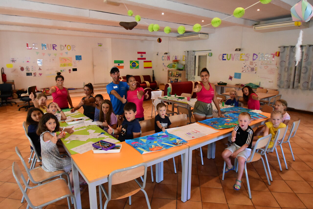 Enfants et animateurs souriants lors d'une activit� cr�ative au camping CAPFUN La Baume.