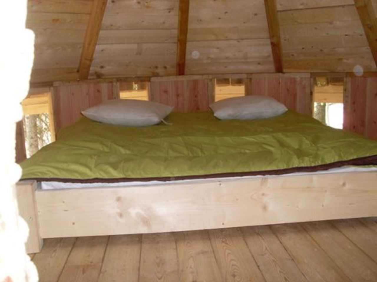 Lit double en bois, couette verte, cabane au CAPFUN Beauregard, Mornas (84).