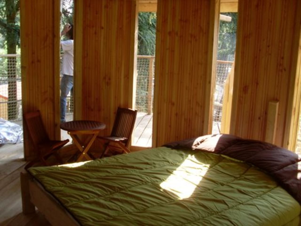 Int�rieur cabane dans les arbres, lit, table, chaises au camping CAPFUN Beauregard.