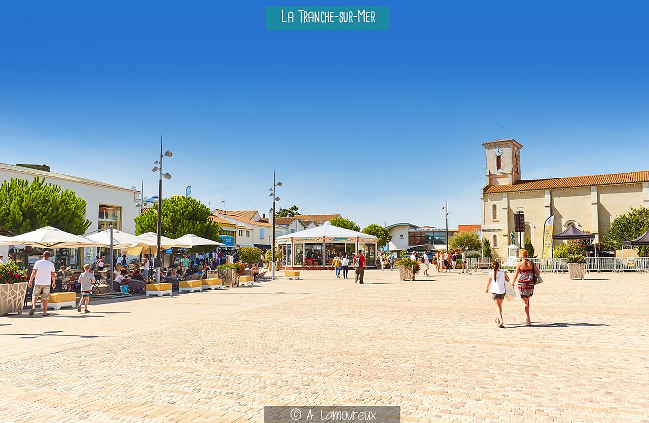 Place centrale anim�e avec carrousel et �glise � La Tranche-sur-Mer (Vend�e).