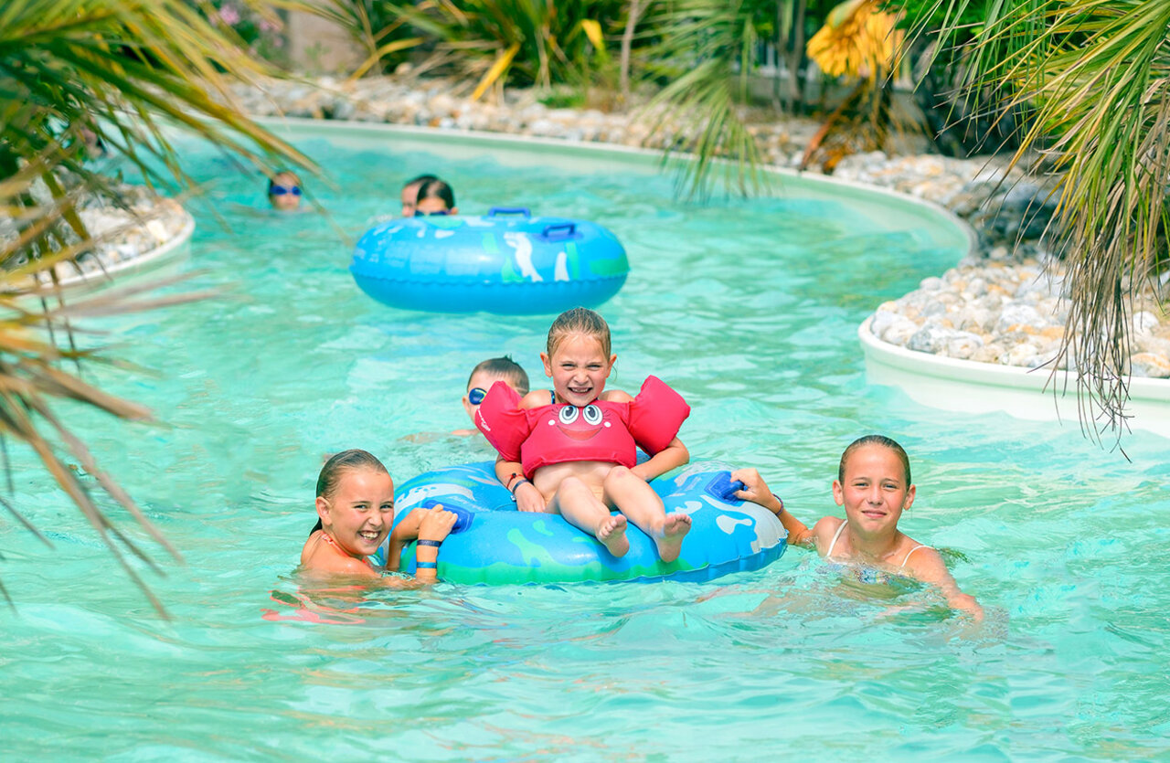 Enfants souriants sur bou�es dans la piscine rivi�re VAGUES OCEANES Bois Joly.