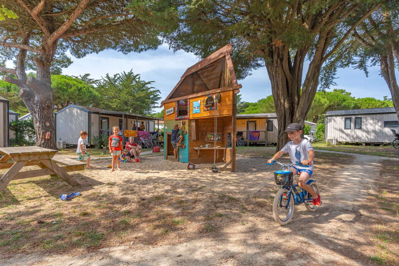 Aire de jeux avec cabane en bois, enfants et mobile-homes au camping CAPFUN Bonne Etoile � BOIS PLAGE EN RE (17).