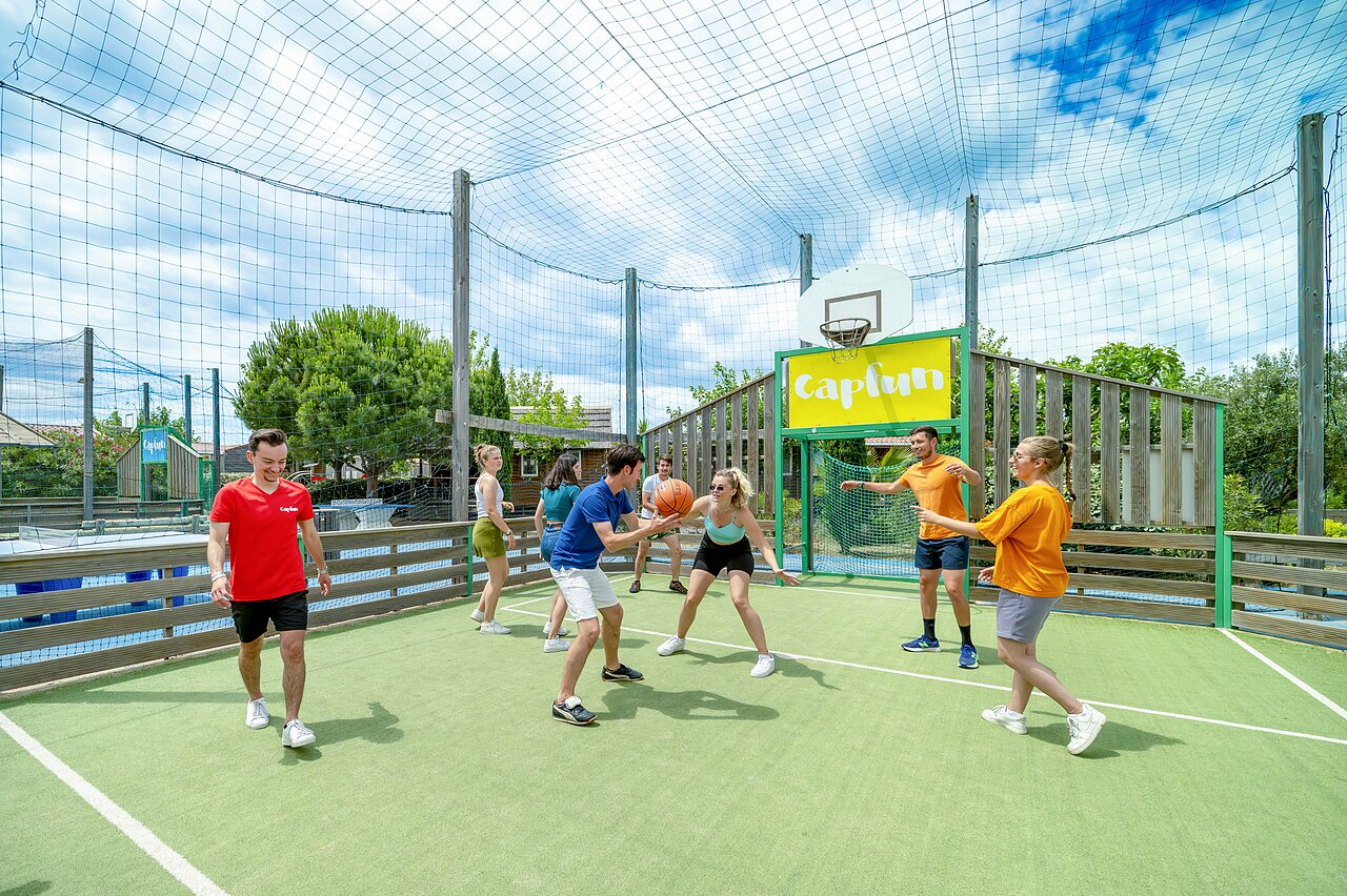 Jeunes jouant au basketball sur terrain multisport au camping CAPFUN Boucanet � LE GRAU DU ROI (30).