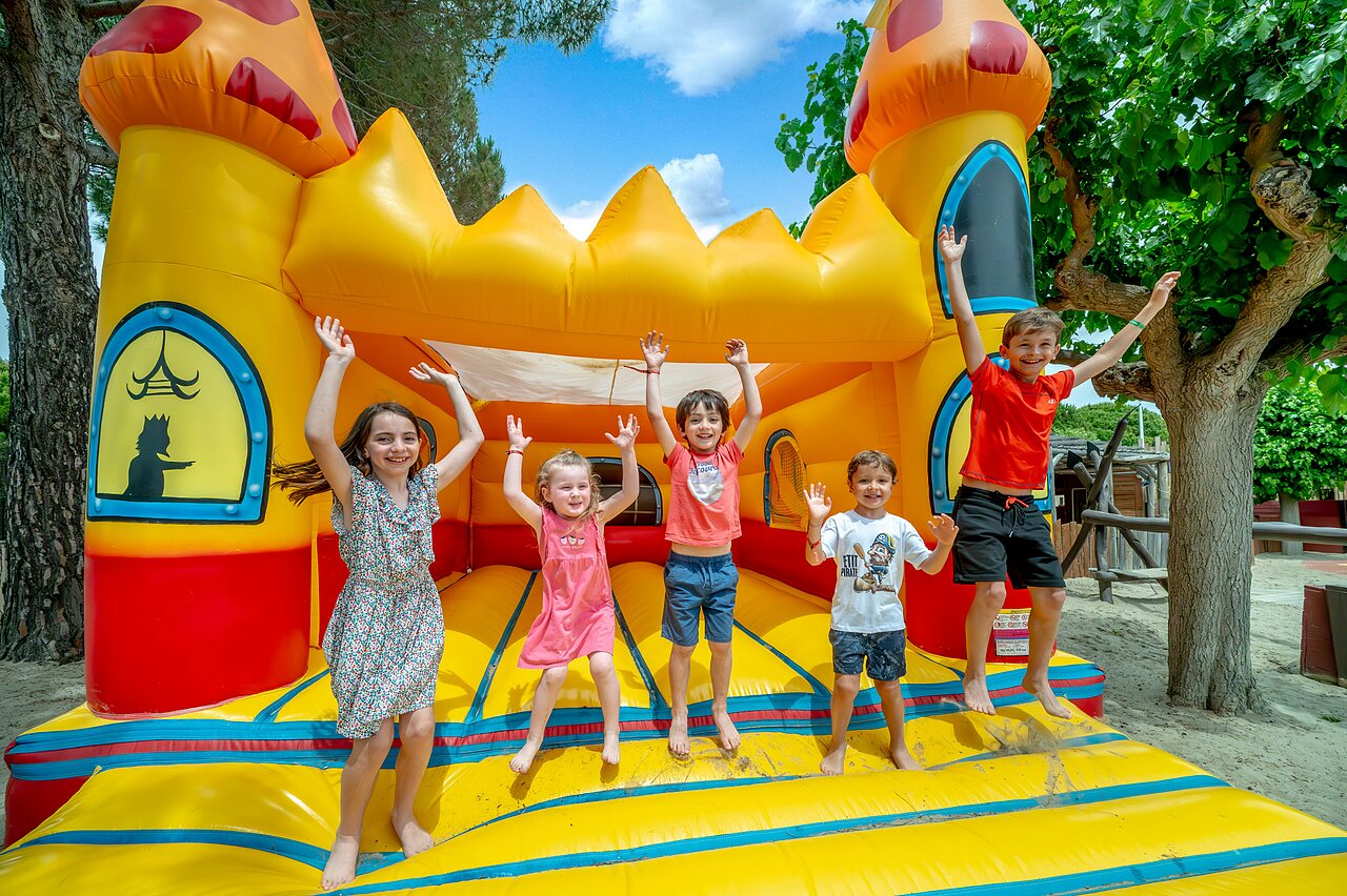 Ch�teau gonflable et enfants joyeux au camping CAPFUN Boucanet � LE GRAU DU ROI (30).
