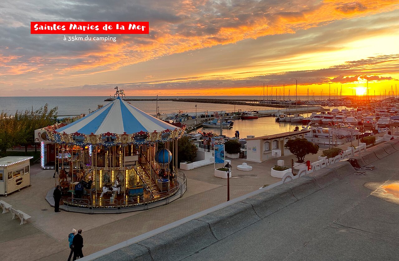 Carrousel et port de plaisance au coucher du soleil � Saintes Maries de la Mer.