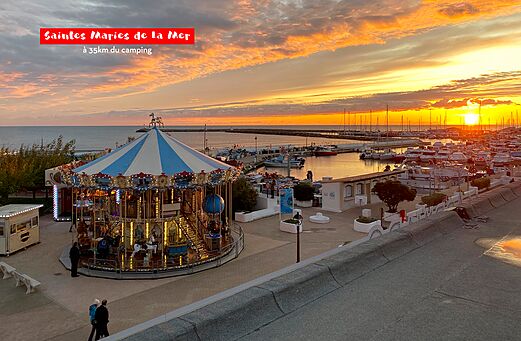 Carrousel et port de plaisance au coucher du soleil � Saintes Maries de la Mer.