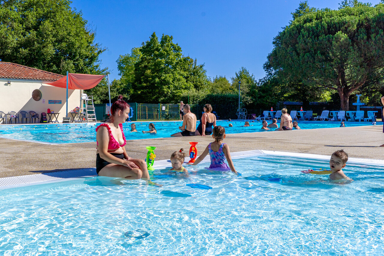 Famille et enfants dans la piscine ext�rieure du camping CAPFUN Breteche � Les Epesses.