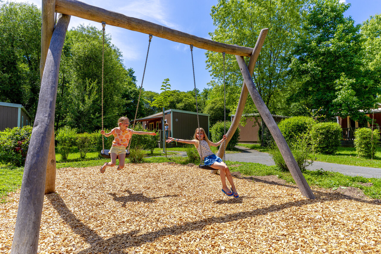 Aire de jeux avec enfants sur balan�oires au camping CAPFUN Breteche � Les Epesses (85).