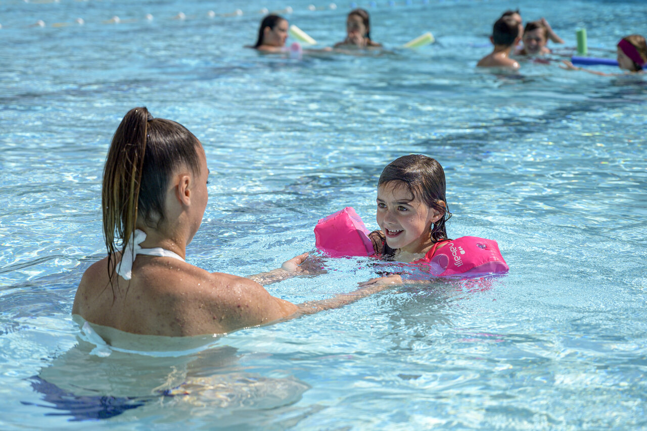 Piscine, enfant souriante avec brassards, au camping CAPFUN Breteche � Les Epesses (85).