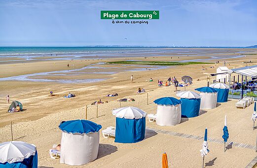 Grande plage de sable de Cabourg avec cabines de plage, à visiter près du camping.