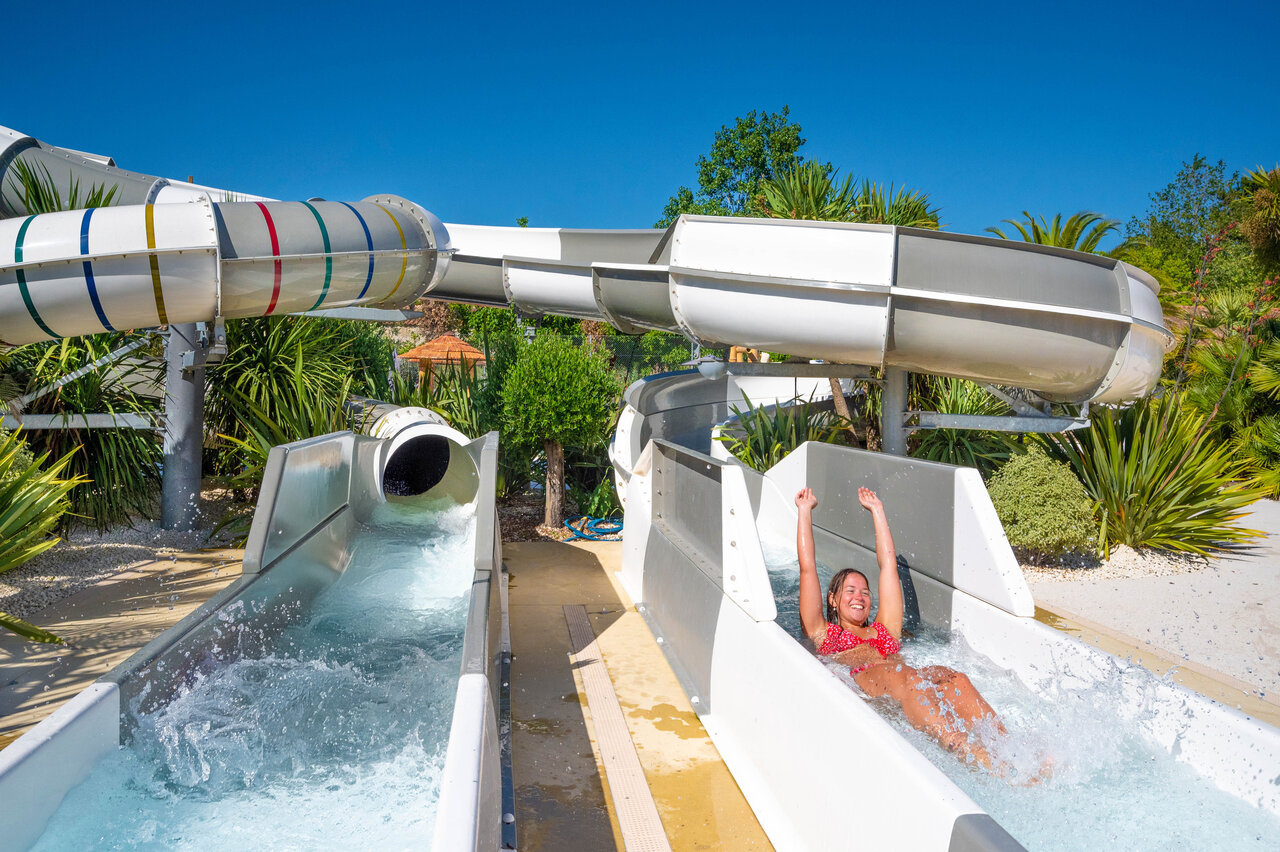 Femme souriante sur toboggan aquatique au camping CLICOCHIC Cabanes d Ol�ron � ST GEORGES D'OLERON.