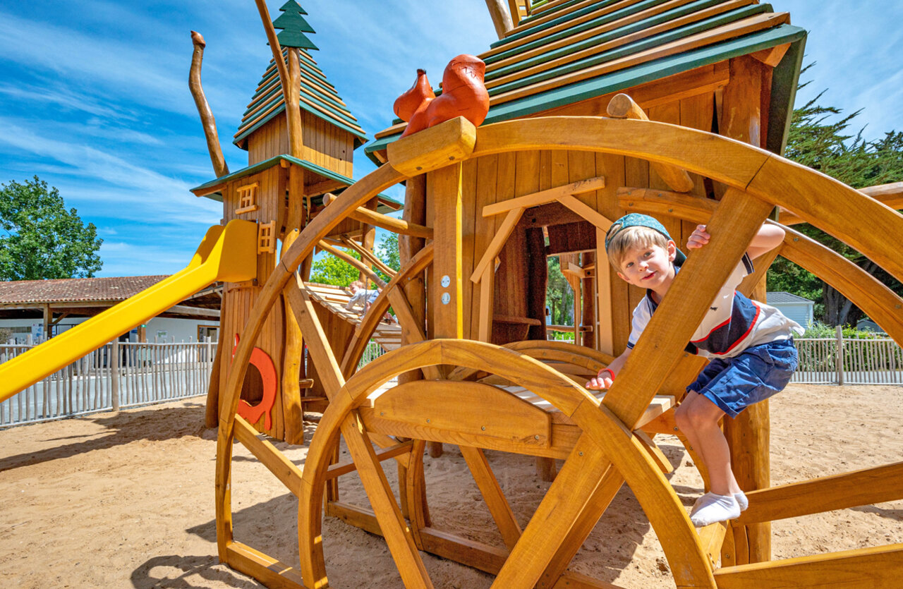 Enfant, aire de jeux en bois au camping CLICOCHIC Cabanes d Ol�ron � ST GEORGES D'OLERON (17).