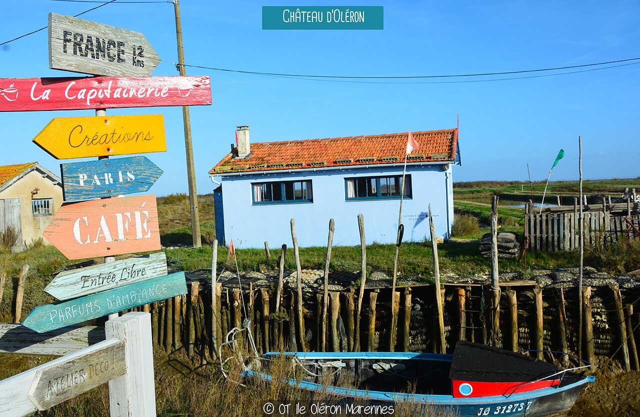 Panneau indicateur color� et maison typique au bord de l'eau � Ch�teau d'Ol�ron.