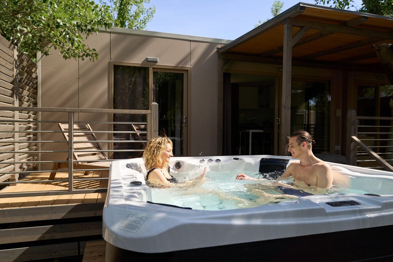 Jacuzzi priv� avec couple sur terrasse de mobil-home au camping CAPFUN Campo dei Fiori � Rosignano Marittimo (57).