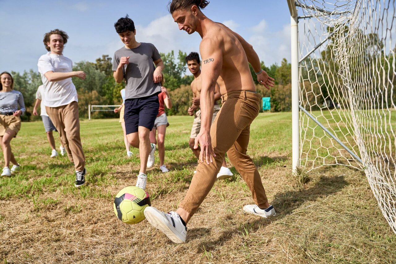 Football entre jeunes sur terrain de sport au camping CAPFUN Campo dei Fiori.