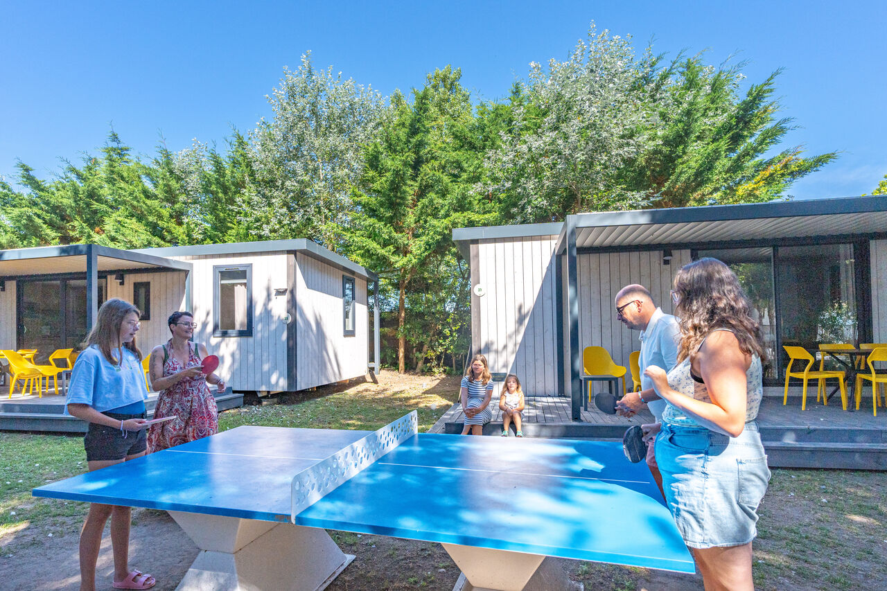Famille jouant au tennis de table au camping CLICOCHIC Camp du Soleil.