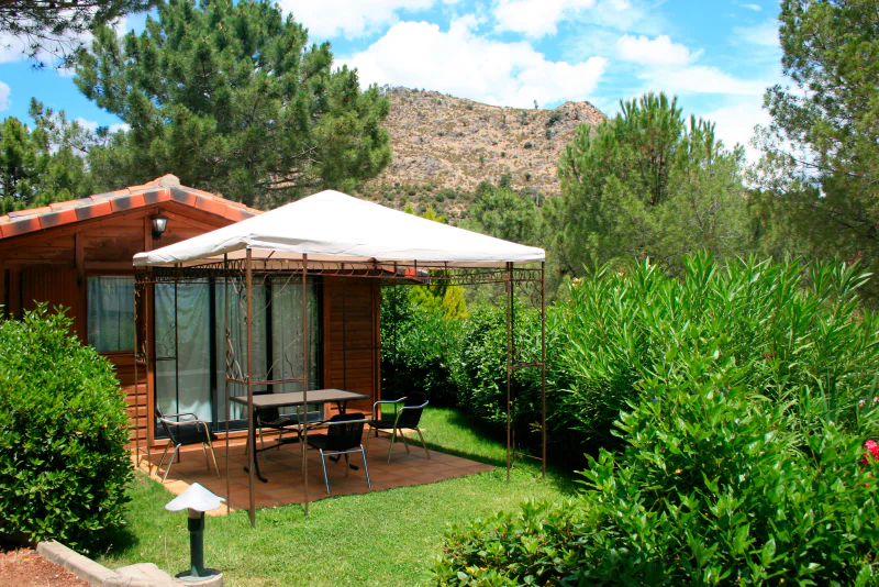 Chalet bois, terrasse ombrag�e et verdure au camping CAPFUN El Canto La Gallina � Valdemaqueda (Madrid).