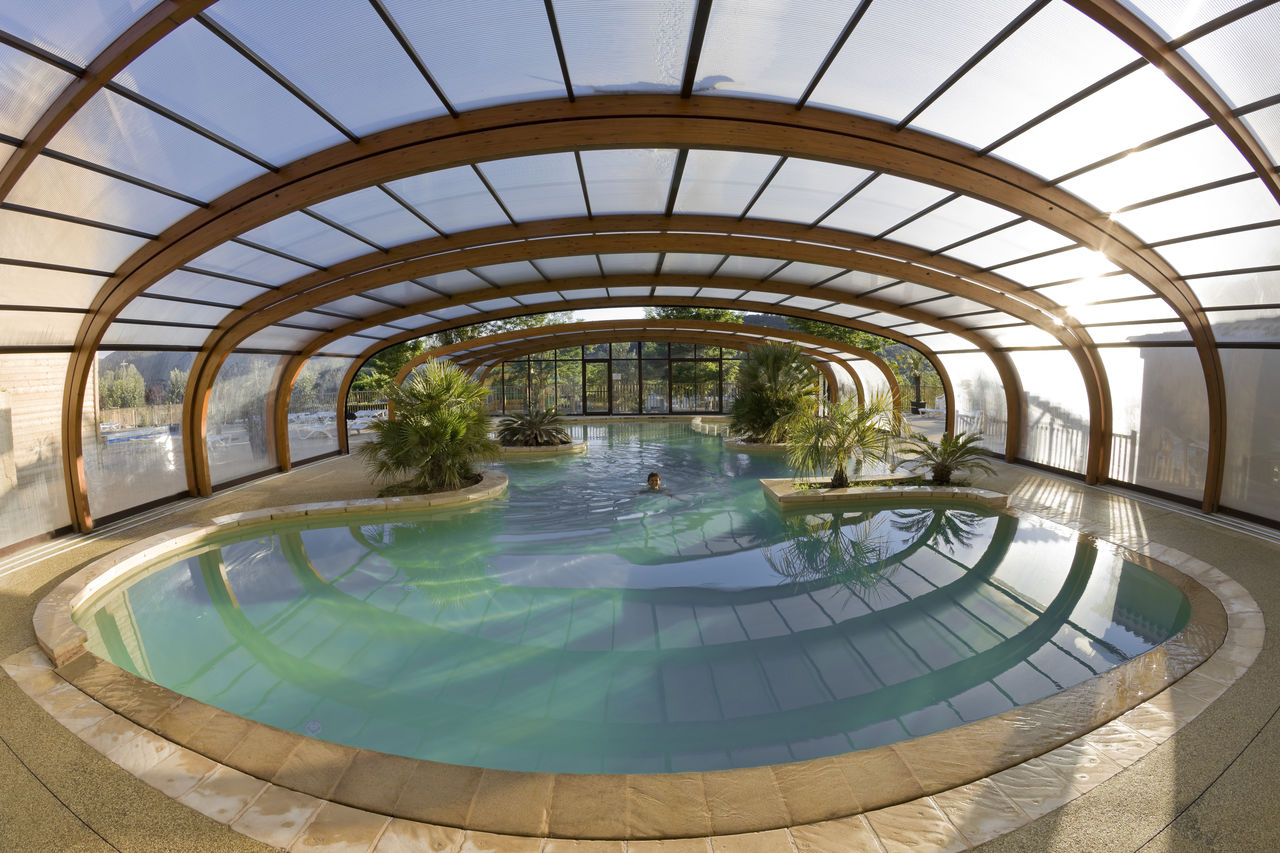 Piscine couverte chauff�e avec palmiers au camping CAPFUN Carpe Diem � VAISON LA ROMAINE (84).