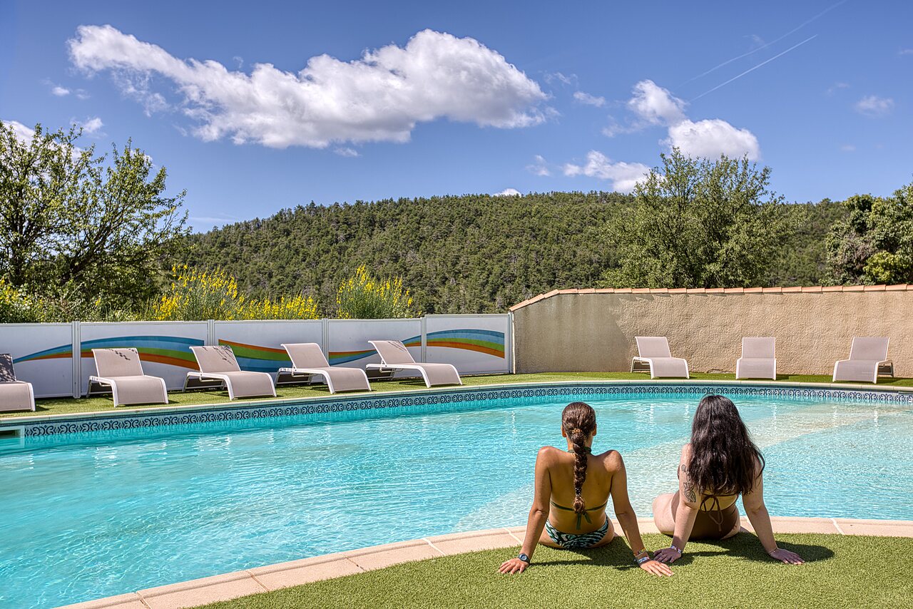 Piscine ext�rieure avec transats, deux femmes au camping CLICOCHIC Castillon de Provence.