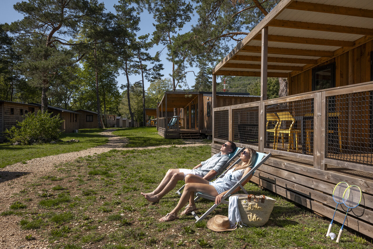 Couple se d�tendant devant mobile-home avec terrasse au camping CLICOCHIC Chancia (01).