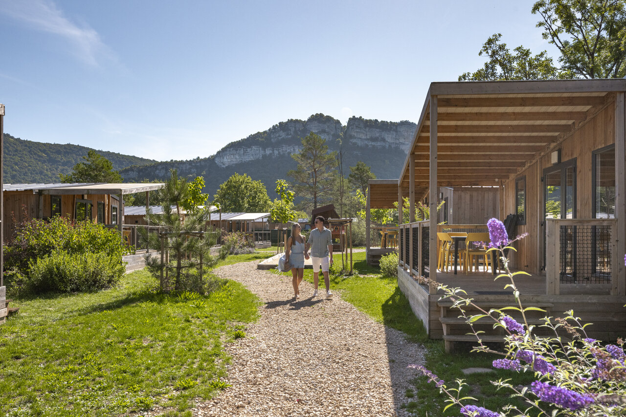 Mobile homes en bois, couple marchant, nature au camping CLICOCHIC Chancia (01).