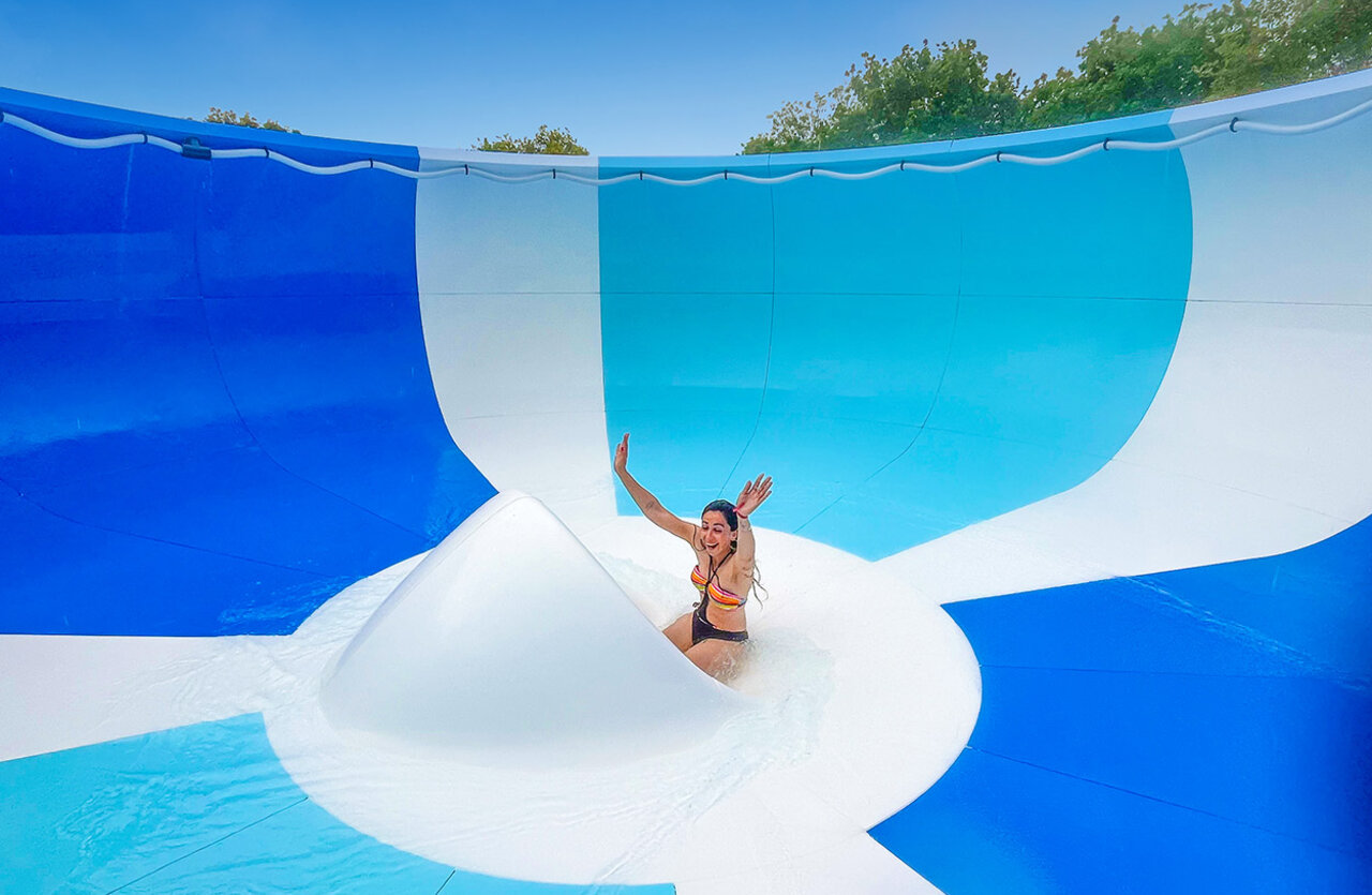 Toboggan aquatique g�ant avec femme souriante au camping VAGUES OCEANES Domaine les Charmilles.