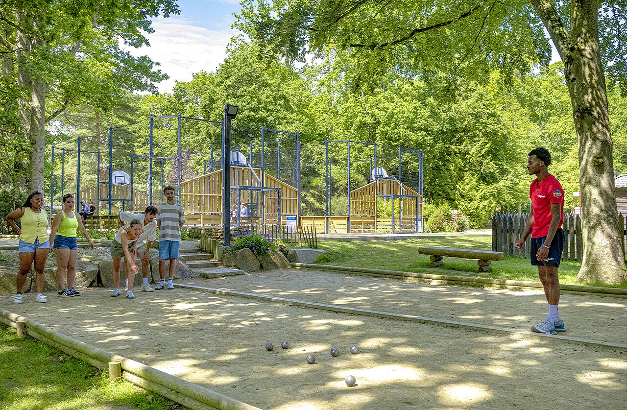 Jeunes jouant � la p�tanque, terrain multisport en arri�re-plan au camping CAPFUN Ch�teau de Galin�e � SAINT CAST LE GUILDO (22).