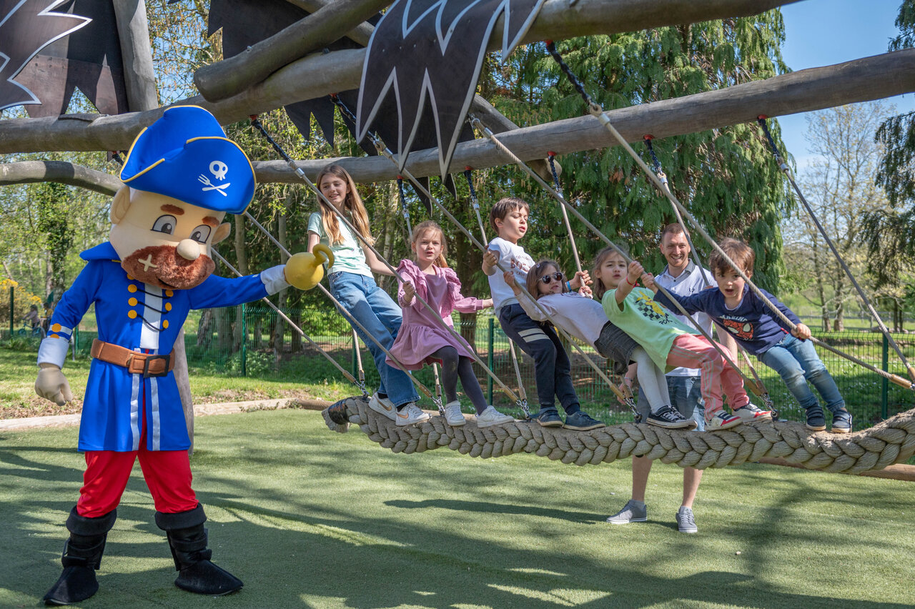 Mascotte pirate et enfants jouant sur un pont de cordes au camping CAPFUN Chateau d'Arvid � Villerville (14).