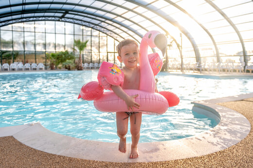 Piscine couverte, enfant avec bou�e flamant rose, CAPFUN Chateau d'Arvid Villerville.