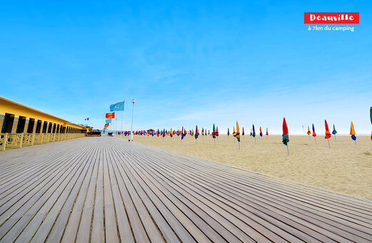 Planche de Deauville avec cabines de plage et parasols color�s en Normandie.