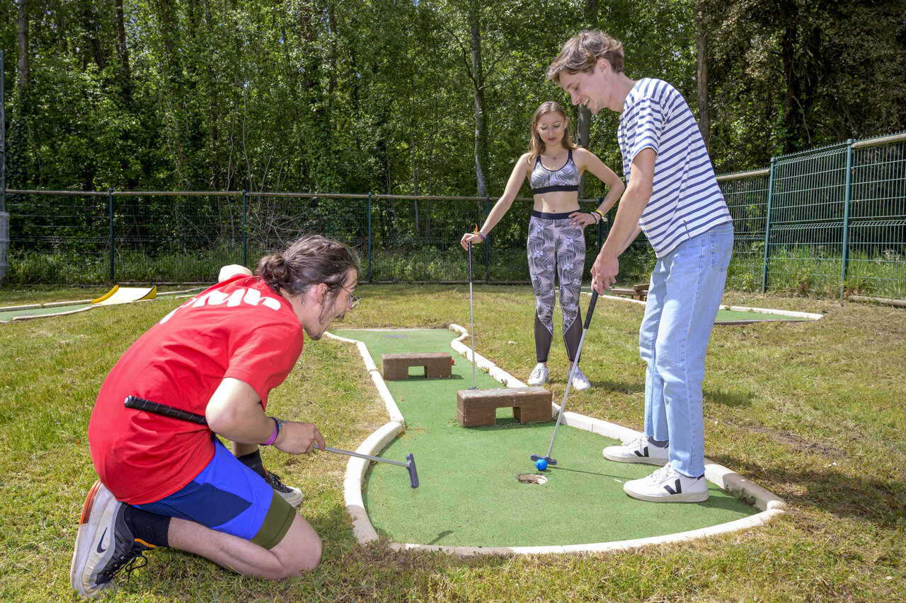 Jeunes s'amusant au mini-golf au camping CAPFUN Ch�nes � Medis/Royan.