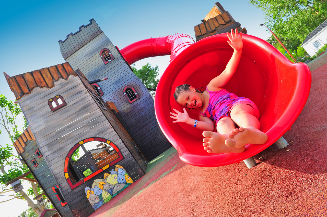 Toboggan rouge et enfant souriant. Aire de jeux CAPFUN Ch�nes � Medis/Royan.