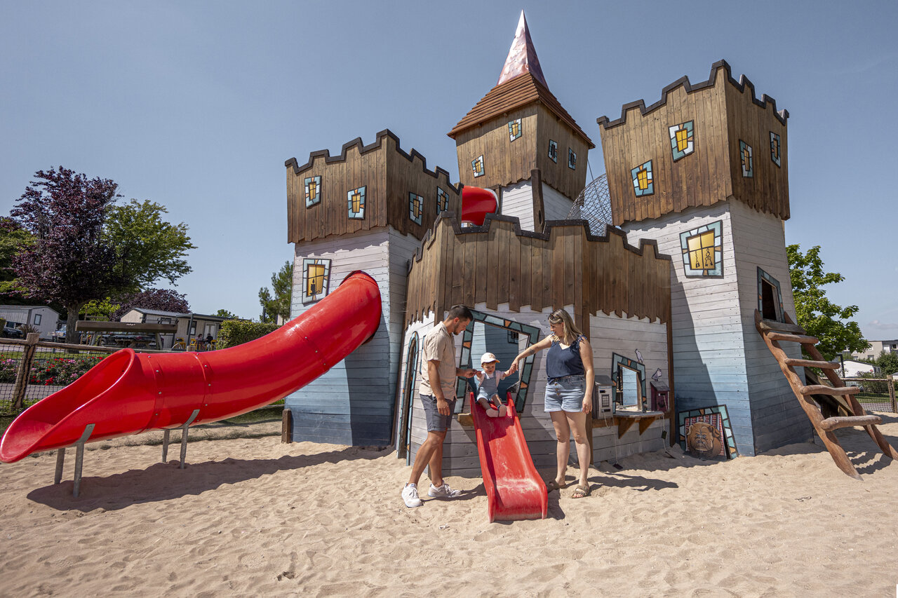 Aire de jeux ch�teau avec toboggans et famille au camping CLICOCHIC Chevaliers � HOULGATE (14).