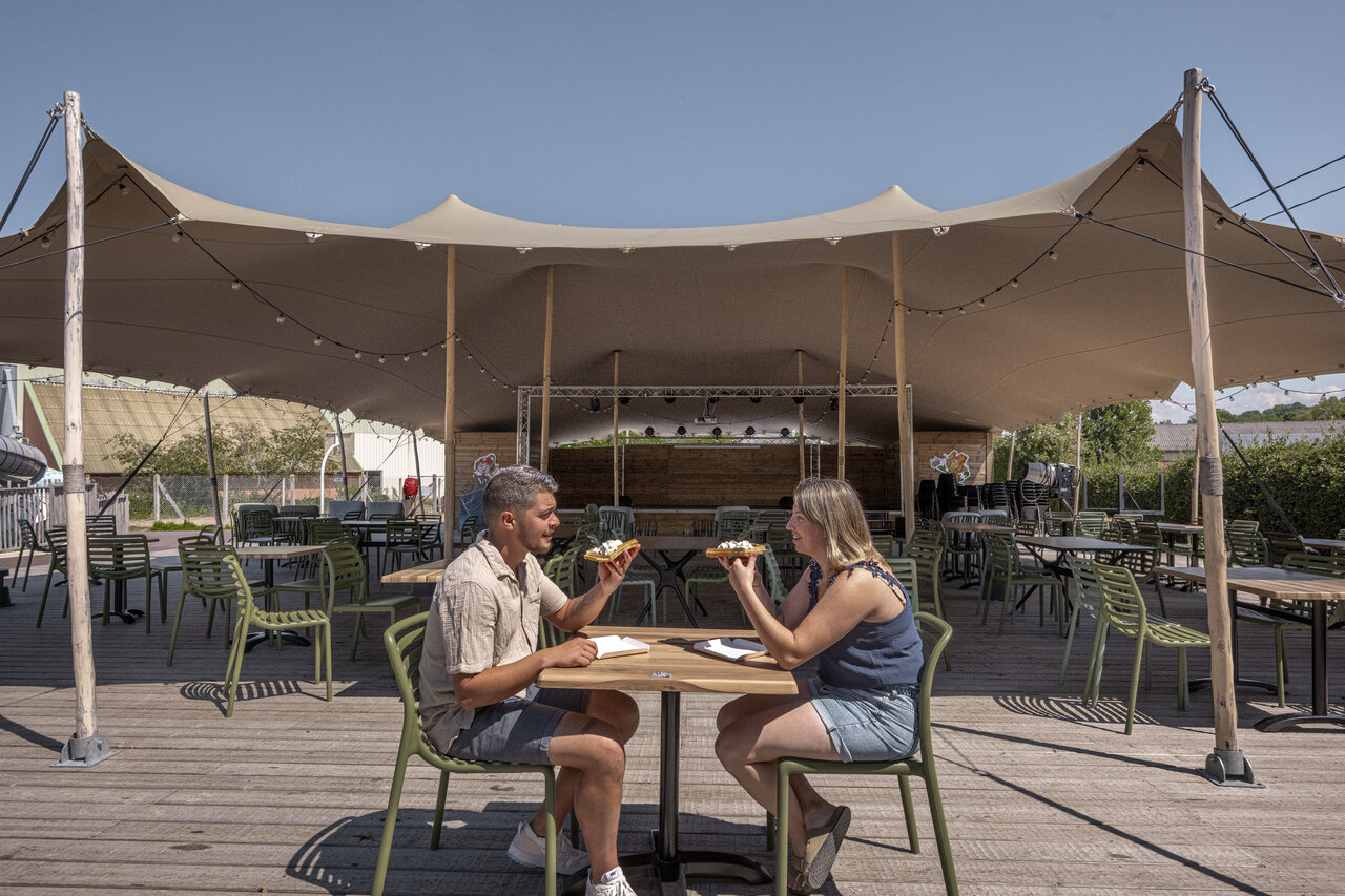 Couple mangeant sur terrasse restaurant anim�e au camping CLICOCHIC Chevaliers � HOULGATE.