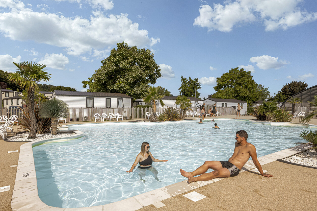 Piscine ext�rieure avec couple et mobile homes au camping CLICOCHIC Chevaliers � HOULGATE (14).