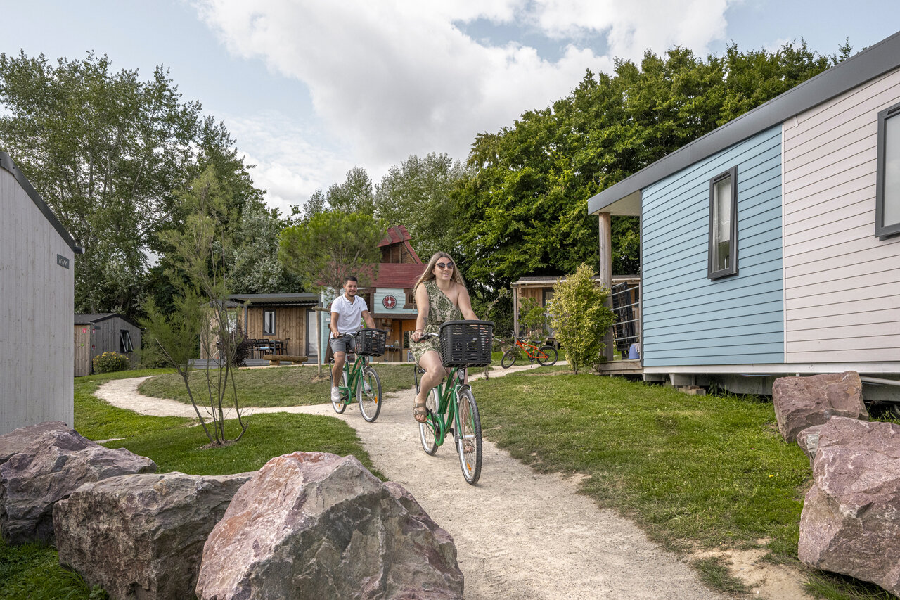 Couple � v�lo devant mobile-homes au camping CLICOCHIC Chevaliers � HOULGATE (14).