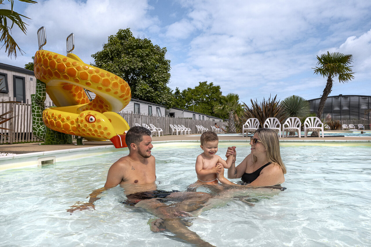Famille avec enfant profitant de la piscine et toboggan serpent au camping CLICOCHIC Chevaliers � HOULGATE (14).